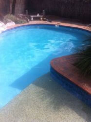 Completed concrete swimming pool repairs in Blue Mist finish